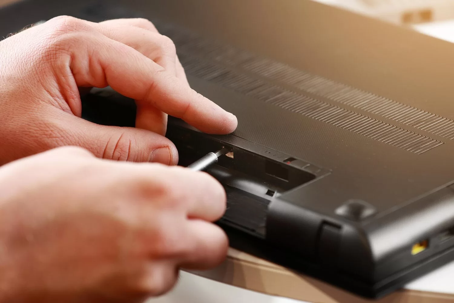 repairmans hands unscrewing screws from laptop case with screwdriver computer service 1048944 29749517